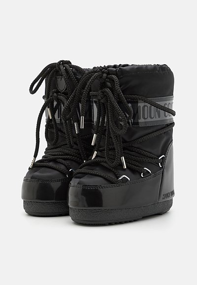 Svarta nylon vinterkängor med en vadderad krage, tjocka gummisulor och dekorativ snörning med metalliska accenter. Strukturerad glänsande yta.