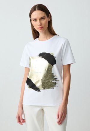 Witte t-shirt met korte mouwen met een gouden en zwarte penseelstreek ontwerp op de voorkant. Ontspannen pasvorm van zacht katoen.