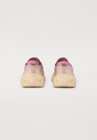 Joggesko med gradientdesign; overdelen er i myk rosa mesh, og sålen er i beige gummi med strukturerte detaljer og en løkke bak på hælen.