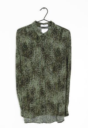 Blusa verde a fantasia con design in pelle di serpente, tessuto leggero, colletto e maniche lunghe, con un orlo inferiore leggermente trasparente.