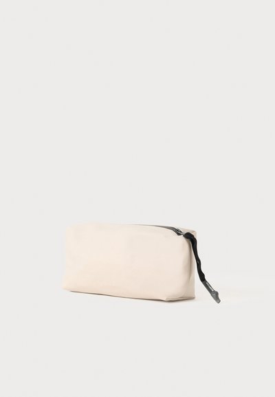 Funda rectangular beige hecha de material texturizado, con una cremallera negra y un asa para un cierre seguro y portabilidad.