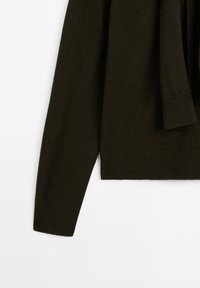 Pull en tricot marron foncé avec manches longues, poignets et ourlet côtelés, et une coupe décontractée pour le confort. Aucun motif ou graphisme visible.