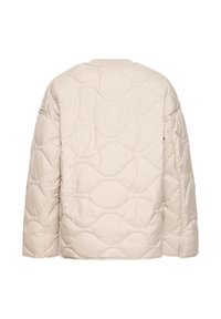 Veste matelassée rembourrée en beige clair, avec un col rond, des épaules tombantes et des formes arrondies sur toute la surface texturée.