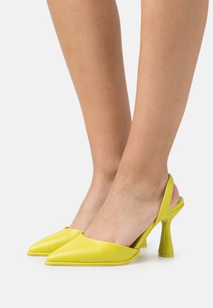 Keltaiset nahkaiset slingback-avokkaat, joissa on terävä kärki ja jäsennelty, kaareva korko. Sileä pinta, jossa on vain vähän ompeleita.