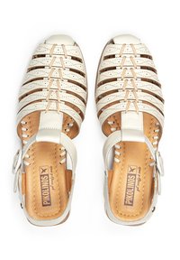 White leather sandals with a strappy design, open toe, and adjustable ankle strap. Brown leather insole and stitched detailing.