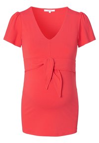 Top premaman color corallo con scollatura a V, maniche corte a sbuffo e dettaglio con laccio frontale. Tessuto morbido e elasticizzato per comfort e vestibilità.