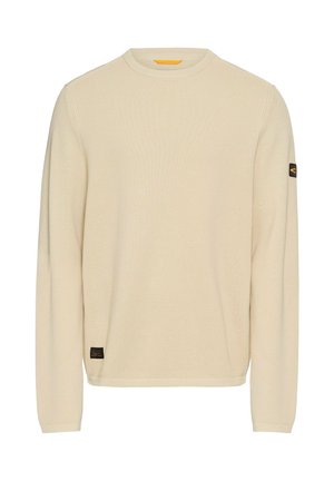 Hellbeige gestrickter Pullover mit langem Arm, runder Halslinie, strukturiertem Stoff und einem kleinen schwarzen Logo-Patch am linken Ärmel.