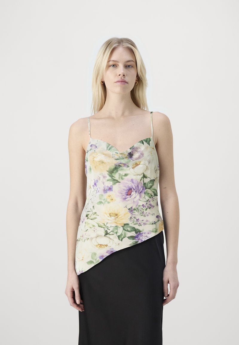 Camisole en satin fleuri couleur crème, avec un décolleté festonné, des fines bretelles et un ourlet asymétrique ornés de fleurs violettes et jaunes.