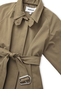 Khaki trenčkot vyrobený z hladké tkaniny s klasickým límcem, páskem v oblasti pasu, velkou přezkou a jemnými detaily šití.