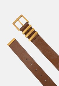 Bruine leren riem met een gouden metalen gesp, voorzien van drie horizontale accenten en vijf gaatjes voor aanpassing. Gladde, gestructureerde afwerking.