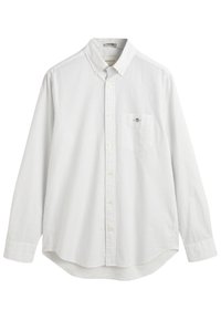 Camisa blanca de botones con pequeños lunares azules. Mangas largas, dobladillo redondeado, bolsillo frontal con detalle del logo en el lado izquierdo. Tejido de algodón.