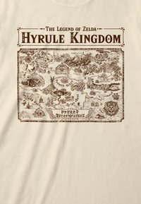 Krämfärgad t-shirt med en detaljerad brun karta över Hyrule-riket från The Legend of Zelda, med intrikata geografiska och konstnärliga inslag.