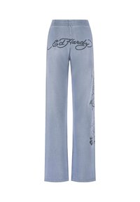 Lichtblauwe wijde jeans met een elastische tailleband, met een zwart Ed Hardy-logo en grafisch ontwerp aan de zijkant. Denim textuur.