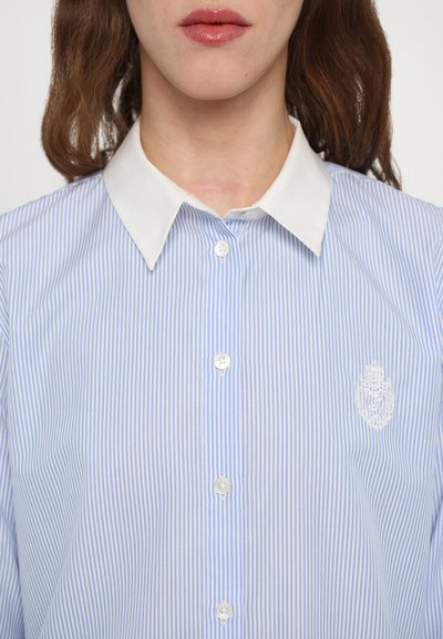 Light blue and white striped shirt with a white collar, featuring buttons down the front and a small embroidered logo on the chest.