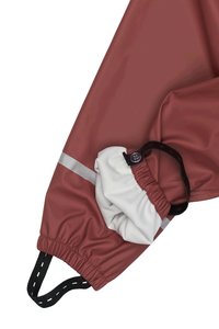 Dyb rød vandtæt jakke med hvid elastisk manchet, sort kordel og refleksstrimmel. Glat tekstur, praktisk design.