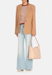 Blazer marrone chiaro, top rigato bordeaux e beige, jeans a gamba larga blu chiaro, borsa in tonalità neutre con tracolla e superficie liscia.