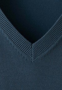 Gros plan d'un pull bleu marine en maille avec col en V côtelé et tissu finement texturé.