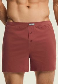 Bordowe bokserki wykonane z miękkiego materiału, z guzikowym zapięciem na dwa guziki oraz oznaczoną metką talią z napisem "HENDERSON CLASSIC".