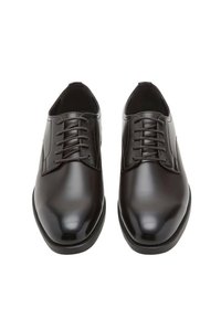 Braune Lederschuhe mit glatter, glänzender Oberfläche, abgerundeter Spitze, sechs Ösen und schwarzer flacher Sohle.