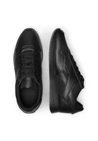 Čierne športové topánky so zmesou koženého a sieťovaného materiálu. Okrúhla špička, šnurovanie a textúrovaná gumová podrážka s jemnými detailami.