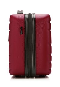 Kompakter roter Hartschalenkoffer mit strukturierter Oberfläche, schwarzem Reißverschluss und oberem Griff, aufrecht stehend vor weißem Hintergrund.