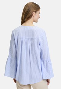 Blau gestreifte Bluse mit Glockenärmeln, Rundhalsausschnitt und gerafftem Rückendetail. Hergestellt aus leichtem Stoff mit einer weichen Textur.
