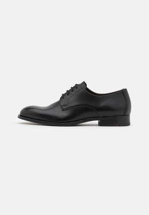 Schwarze Lederdressschuhe mit runder Zehenform, sechs Ösen, glatter Oberfläche und niedrigem, gestapeltem Absatz. Mit subtilen Nähdetails.
