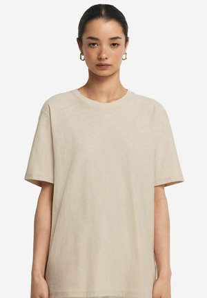 Beige kortærmet t-shirt lavet af letvægtsmateriale; har en rund halsudskæring og en afslappet pasform med en glat tekstur.