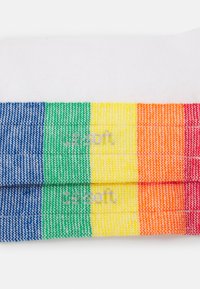 Calzini a righe colorate con sezioni blu, verde, giallo, arancione e rosso. Realizzati in un materiale intrecciato con una texture liscia.