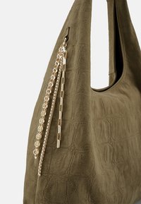 Olijfgroene suède tote bag met een gestructureerde vorm; met gouden kettingaccenten die aan de zijkant hangen.