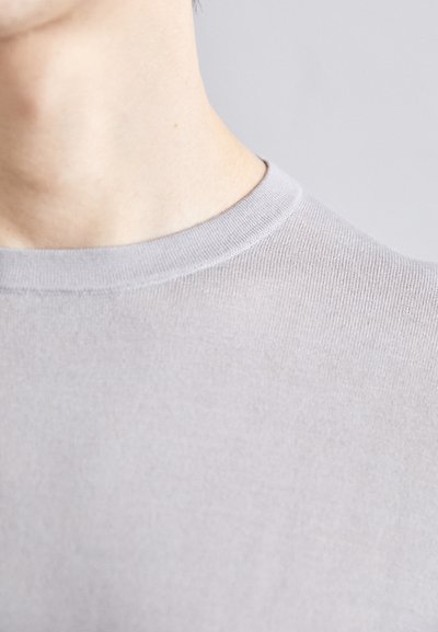 Pull léger gris, ajusté, avec un col rond. Texture douce et détails côtelés au niveau du col. Gros plan sur la zone du cou.