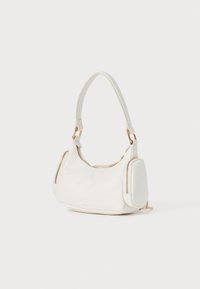 White leather handbag with a curved shape, zippered side pockets, and a short top handle. Gold hardware accents add detail.