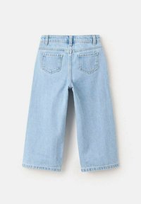 Blugi din denim albastru deschis, cu croială largă a picioarelor, având două buzunare în spate și o talie tradițională. Țesătura are o textură netedă.