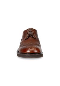 Ruskeat nahkakengät, joissa on brogue-yksityiskohtia, pyöreä kärki ja viisi rei'itettyä nauhakohdetta. Suora pinta alhaalla olevan kumipohjan kanssa.