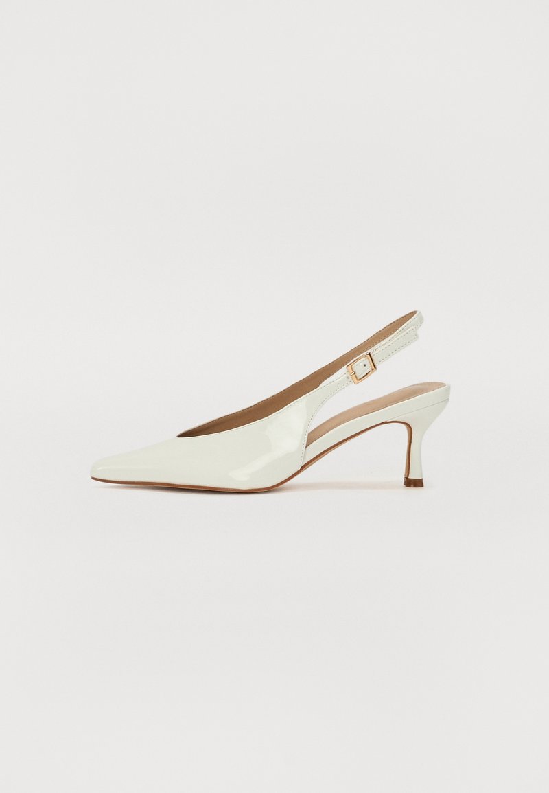 Zapatos de tacón slingback de charol blanco con punta afilada, tacón bajo y correa ajustable que presenta un acento de hebilla en tono dorado.