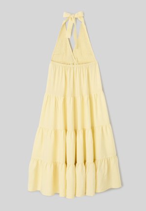 Robe jaune à col halter avec corsage smocké et jupe fluide à volants, nouée en nœud au cou.