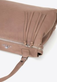 Borsa a mano in pelle marrone chiaro con chiusura a zip, frange allungate e logo argentato. Include una tracolla rimovibile e una superficie testurizzata.