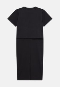 Robe noire à manches courtes avec un haut court et une jupe arrivant au genou. Elle présente une coupe droite, un détail de fente à l'avant et un tissu doux et texturé.