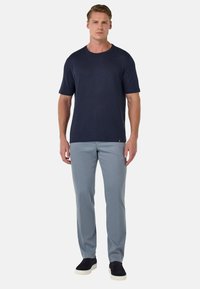 Mornarska kratka majica s kratkimi rokavi, okroglim izrezom, v kombinaciji s svetlo modrimi slim-fit hlačami in črnimi supergami. Preprost dizajn in udoben kroj.