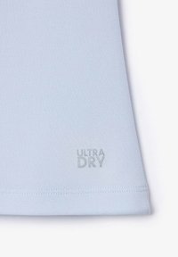Tissu bleu clair avec un ourlet cousu et le texte "ULTRA DRY" imprimé près du bord inférieur.