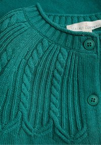 Leśnozielony dzianinowy kardigan z wzorem prążkowanym i warkoczowym, okrągłym dekoltem oraz dwoma turkusowymi guzikami z przodu.