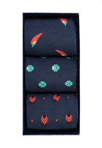 Marineblaue Socken mit Mustern von Chilischoten, Kleeblättern und Erdbeeren in Rot und Grün, präsentiert in einer rechteckigen Box. Weicher Stoff.