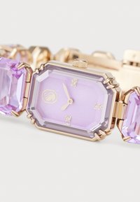 Octagonal watch with a light purple face, gold accents, and crystal markers. Features a bracelet of large purple gemstones.