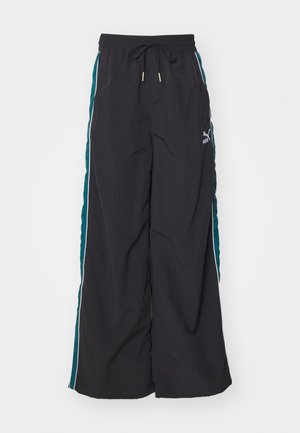 Zwarte wijde broek met een drawstring tailleband, teal zijkanten en witte accentstripes. Gemaakt van een gladde, lichte stof.