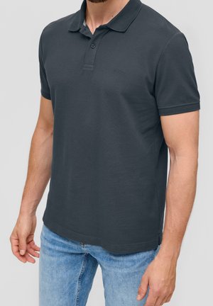 Dunkelgraues Polohemd aus strukturiertem Stoff mit klassischem Kragen, Knopfleiste mit drei Knöpfen und kurzen Ärmeln, kombiniert mit hellblauen Jeans.