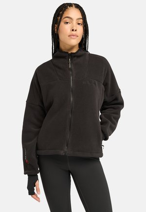 Schwarze Fleecejacke mit hohem Kragen, Frontreißverschluss und zwei Seitentaschen. Verfügt über Daumenlöcher an den Bündchen und ein dezentes Logodesign.