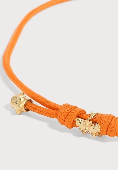 Bracelet en cordon tressé orange avec breloques étoile dorées et détail de nœud sur fond clair.