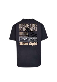 Tricou negru din bumbac cu text crem: "BUENOS AIRES BUE 2024" și logo-uri, având un detaliu cu model pătrățos și "Ultra Light" în partea de jos.