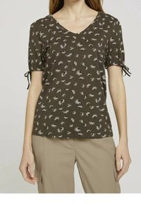 Blusa verde de manga corta con escote en V y estampado floral. Presenta mangas fruncidas con cintas y una tela suave y texturizada.