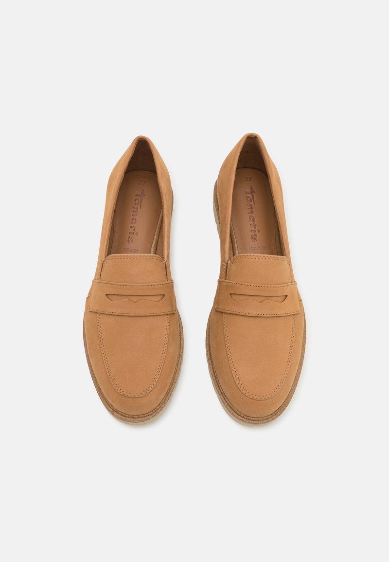 Mocassins en suede beige avec un design cousu, bout rond et une bande surélevée sur le dessus. Semelle légère avec une finition texturée.